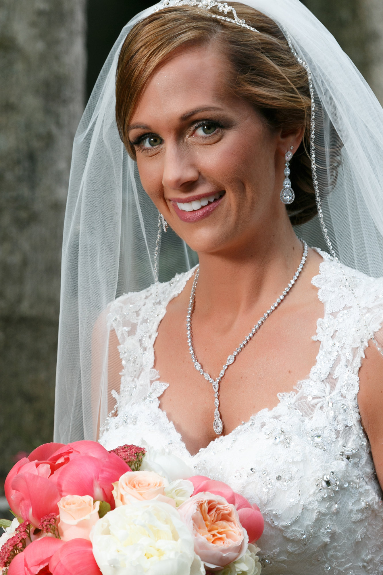 Melissa smiles in wedding gown with bouquet
